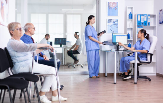 Medical nurses holding patient radiography Senior woman with walking frame in hospital waiting room for rehabilitation treatment. Medical staff discussing about patient x-ray.